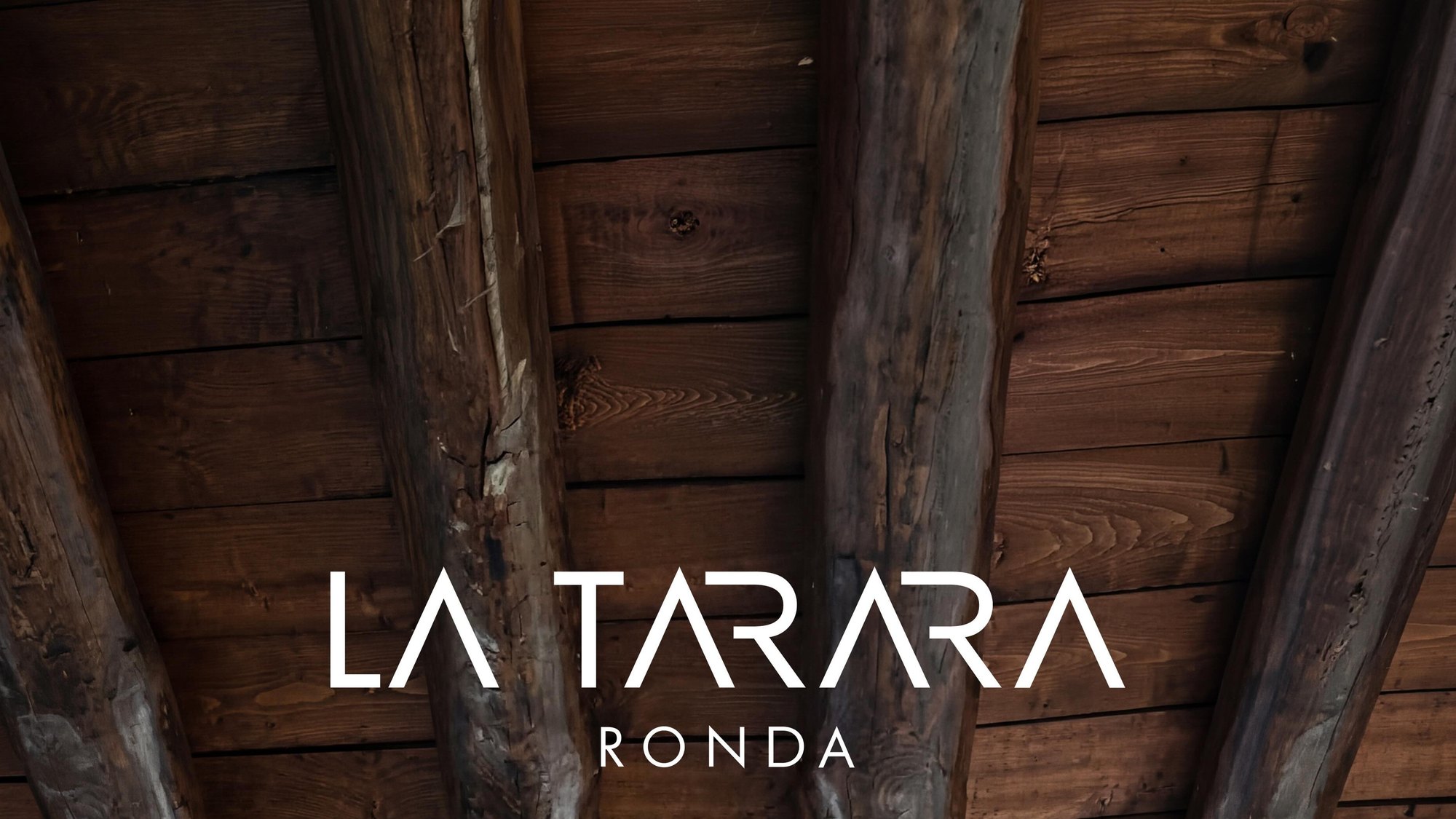 Rótulo de madera La Tarara sobre pared de madera rústica